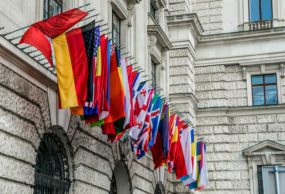 Rekke av nasjonale flagg på fasaden til en diplomatisk bygning, symbolet på de internasjonale beskikkingene hver utenrikstjeneste opprettholder rundt om i verden.